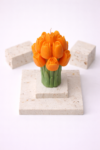 Orange Tulpenkerze auf Travertinplatten