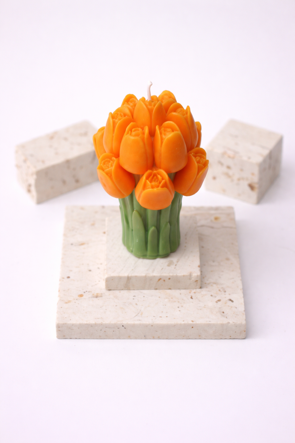 Orange Tulpenkerze auf Travertinplatten